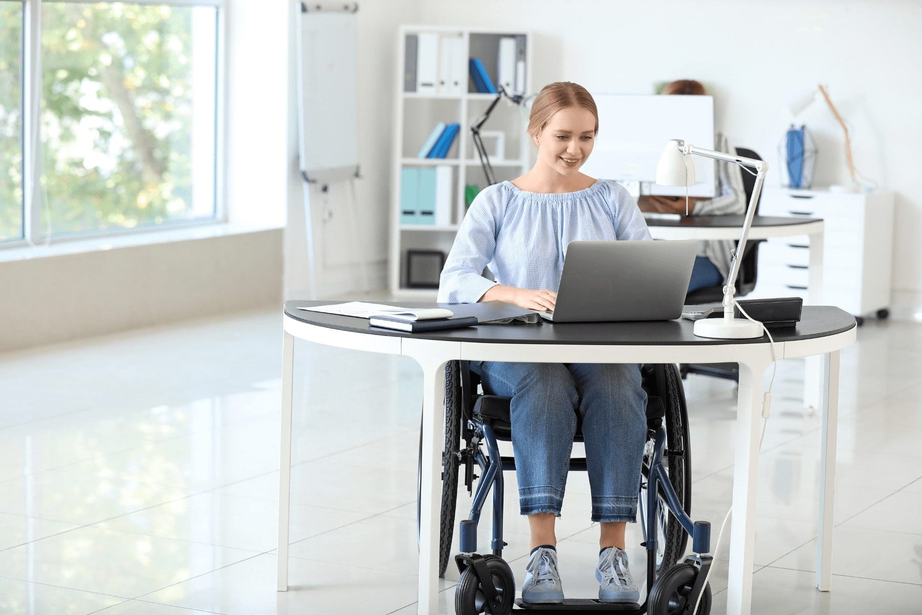woman in a wheelchair working in a ADA compliant workplace